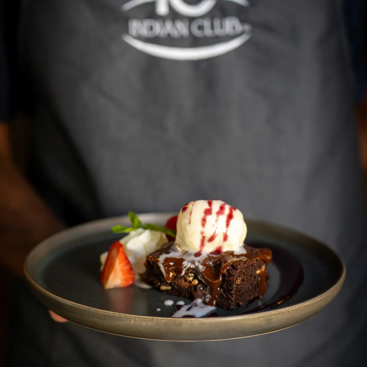 Server presenting dessert dish with ice cream.