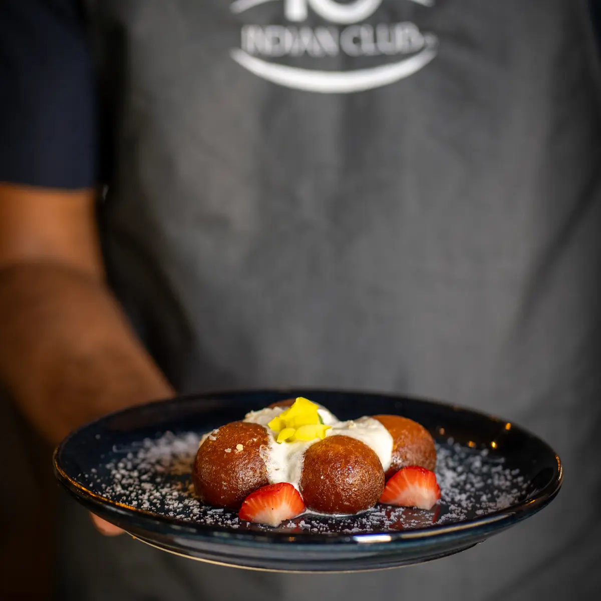 Server presenting dessert dish.