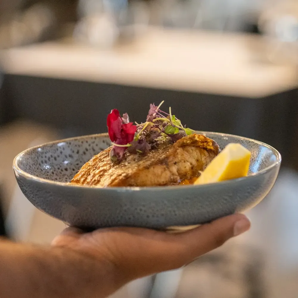 Server holding a plate of main food.