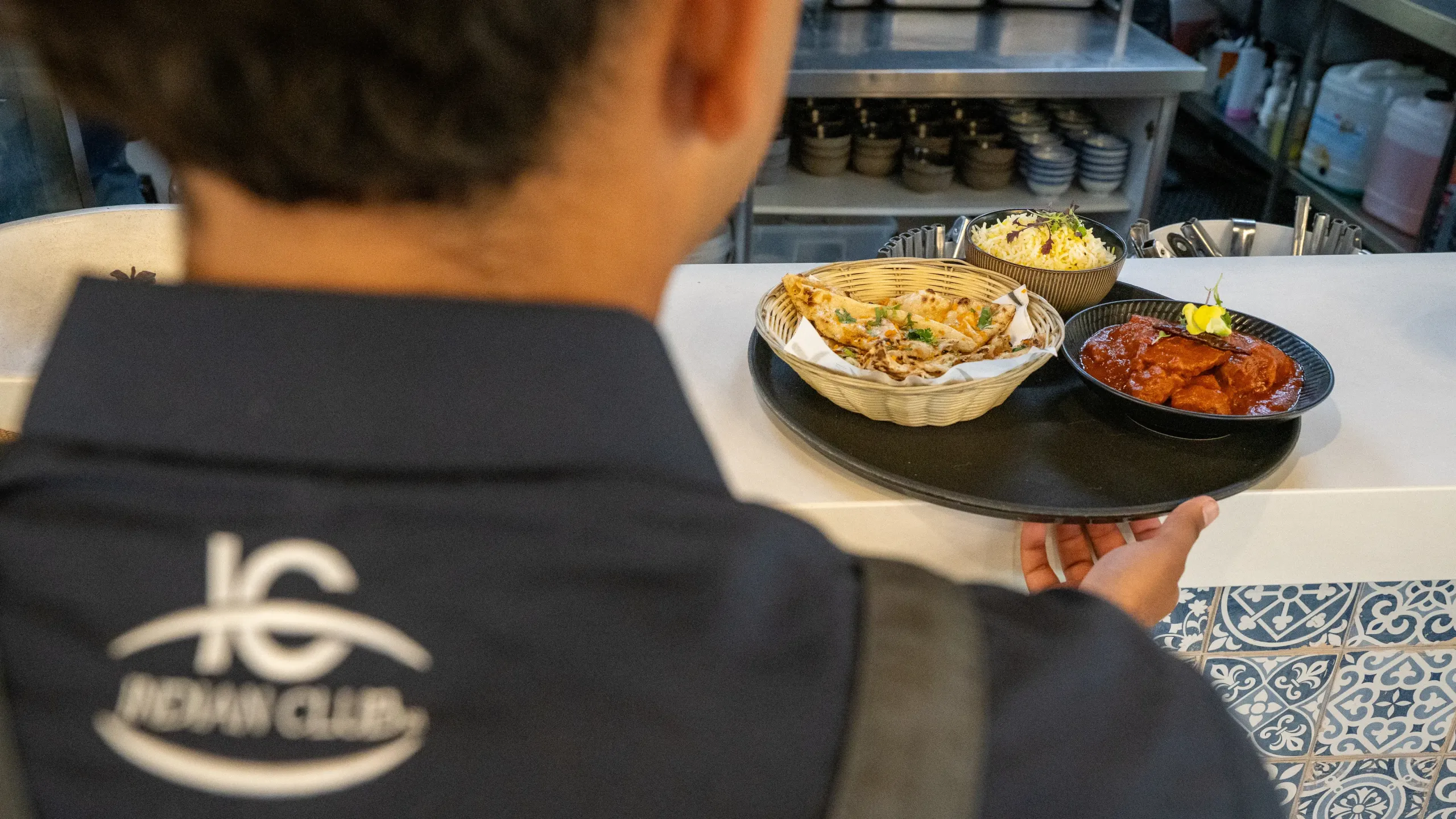 Waiter getting food from kitchen counter.